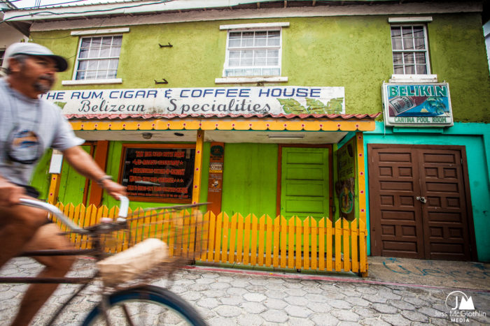 Jess McGlothlin Media. Belize photography. Image of man on bicycle in front of market in San Pedro, Belize. 