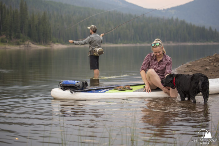 Jess McGlothlin Media. Man, woman and Labrador retriever dog play and fish at a mountain lake in Montana.